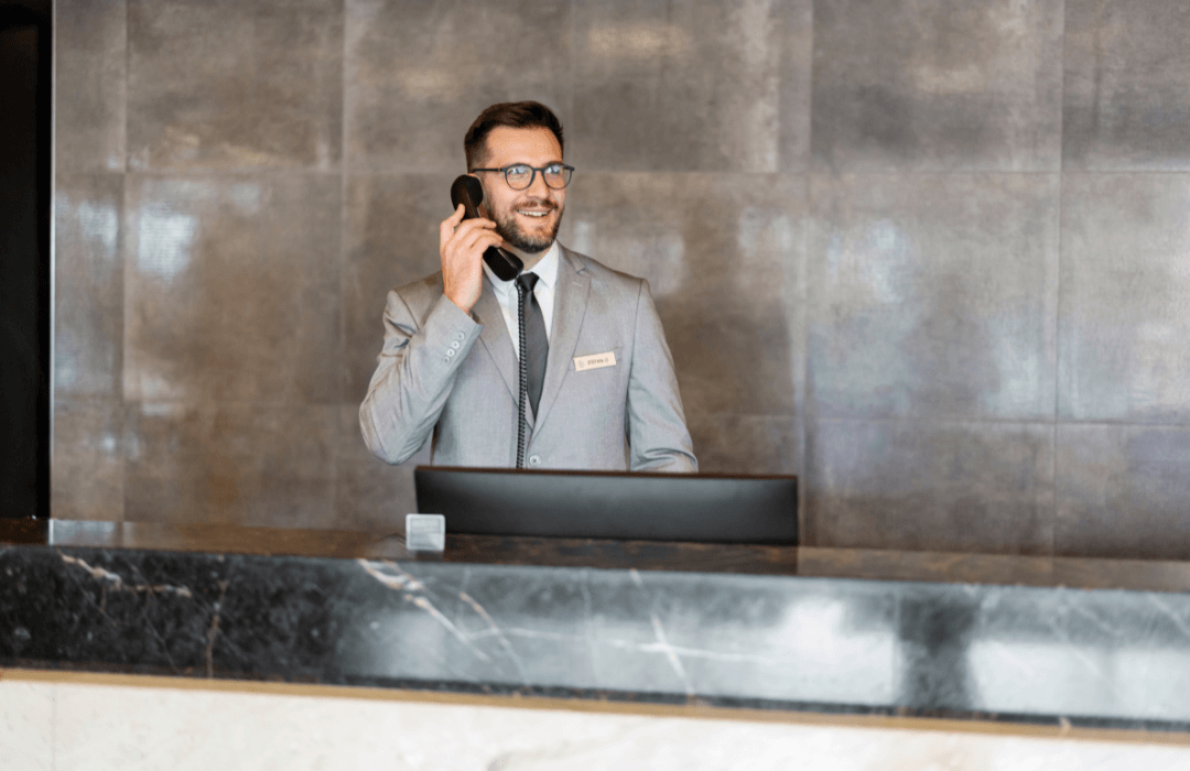 Hotel front desk staff receiving phone call through PBX phone system.